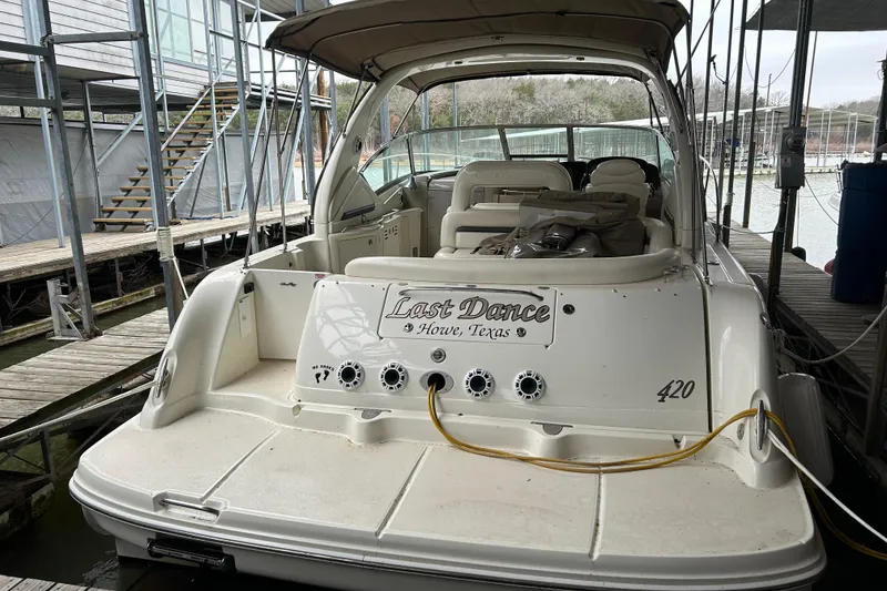 Slide: The Image of 2004 Sea Ray 420 Sundancer docked, rear view with "Last Dance" nameplate. - 4
