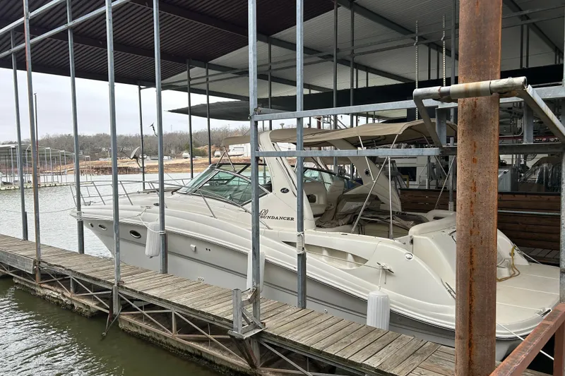 Slide: The Image of 2004 Sea Ray 420 Sundancer docked in a marina under a covered shelter. - 7