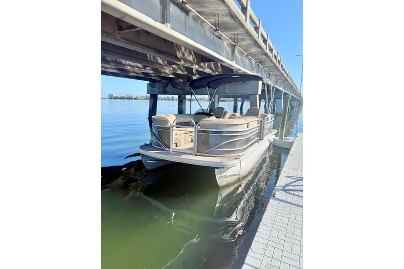 The Image of 2023 Sun Tracker Party Barge 22 DLX pontoon boat docked under a bridge. - 0