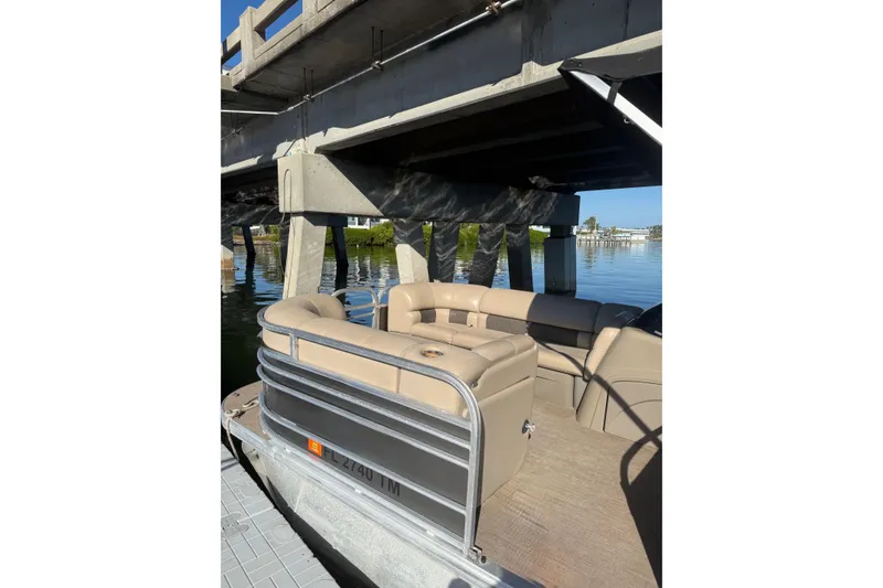 Slide: The Image of 2023 Sun Tracker Party Barge 22 DLX pontoon boat under a bridge on calm water. - 8
