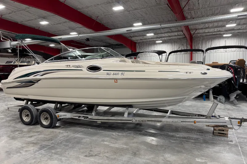 The Image of 2004 Sea Ray 240 Sundeck boat on trailer in indoor showroom. - 1