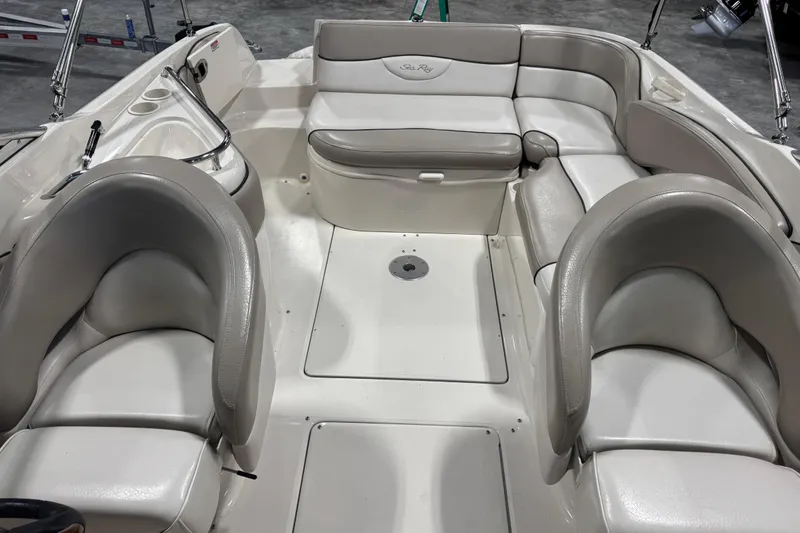 Slide: The Image of 2004 Sea Ray 240 Sundeck interior with white and gray seating arrangement. - 10