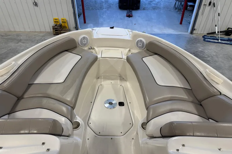 Slide: The Image of 2004 Sea Ray 240 Sundeck interior with beige seating and speakers in a garage setting. - 12
