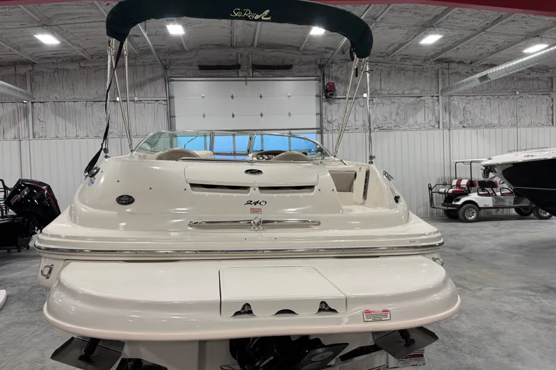 Slide: The Image of 2004 Sea Ray 240 Sundeck boat in a spacious indoor storage facility. - 5