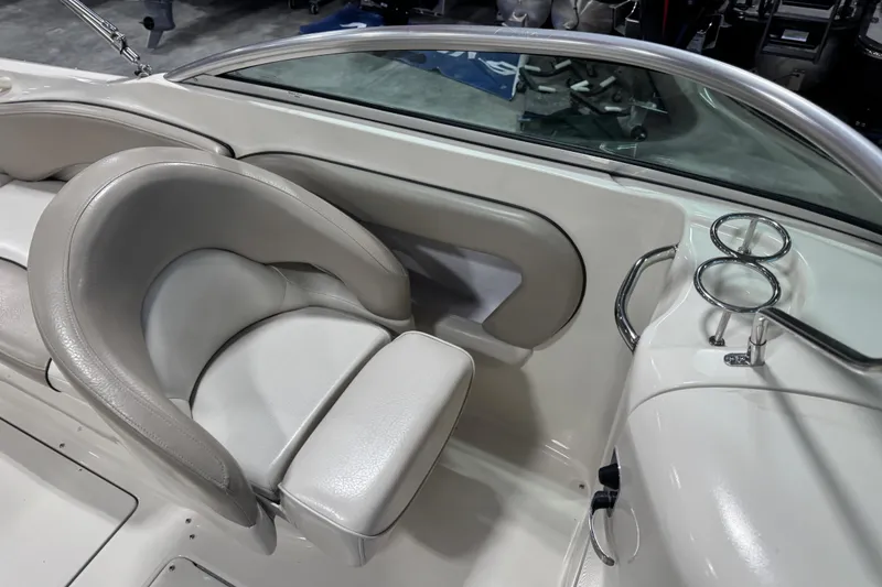 Slide: The Image of 2004 Sea Ray 240 Sundeck interior with beige seating and cup holders. - 9