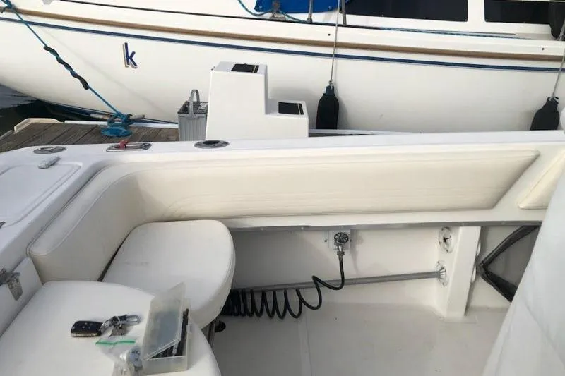 Slide: The Image of 2004 Fountain 31 Tournament Edition boat interior with seating and docked vessel. - 23