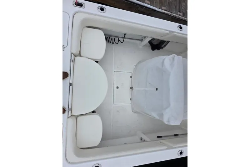 Slide: The Image of 2004 Fountain 31 Tournament Edition boat interior with white seating and covered console. - 24