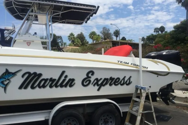Slide: The Image of 2004 Fountain 31 Tournament Edition boat named "Marlin Express" on trailer, with palm trees in background. - 9
