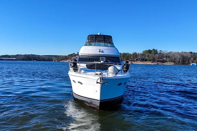 Slide: The Image of Front view of 2001 Carver 570 Voyager Pilothouse yacht on a lake. - 13
