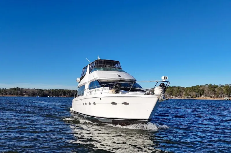 Slide: The Image of 2001 Carver 570 Voyager Pilothouse yacht cruising on a clear blue lake. - 7