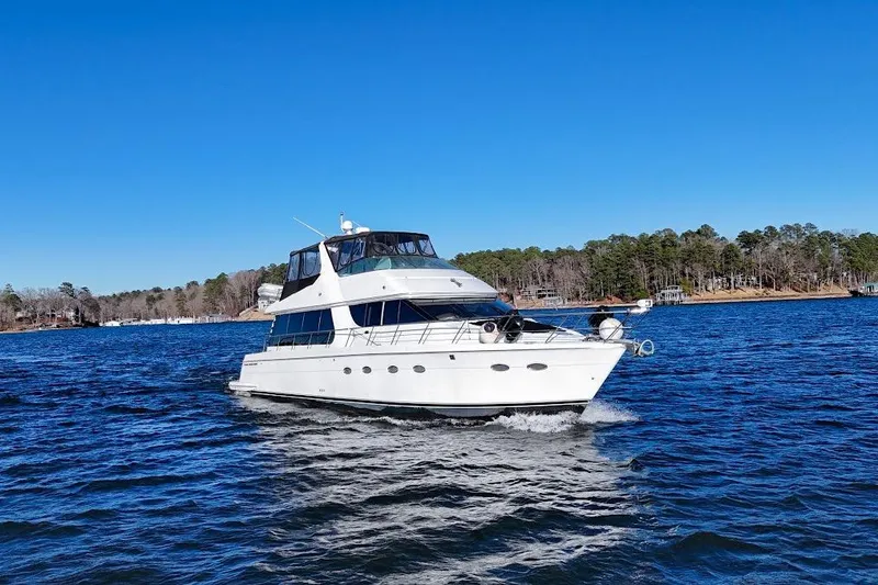 Slide: The Image of 2001 Carver 570 Voyager Pilothouse yacht cruising on a clear blue lake. - 10
