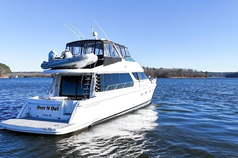Slide: The Image of 2001 Carver 570 Voyager Pilothouse yacht cruising on a serene lake under clear blue skies. - 16