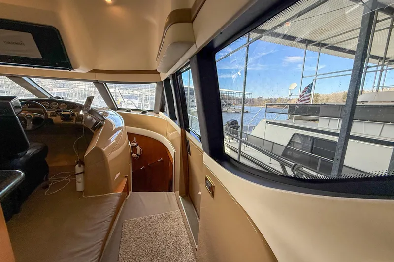 Slide: The Image of Interior view of 2001 Carver 570 Voyager Pilothouse with marina in background. - 25