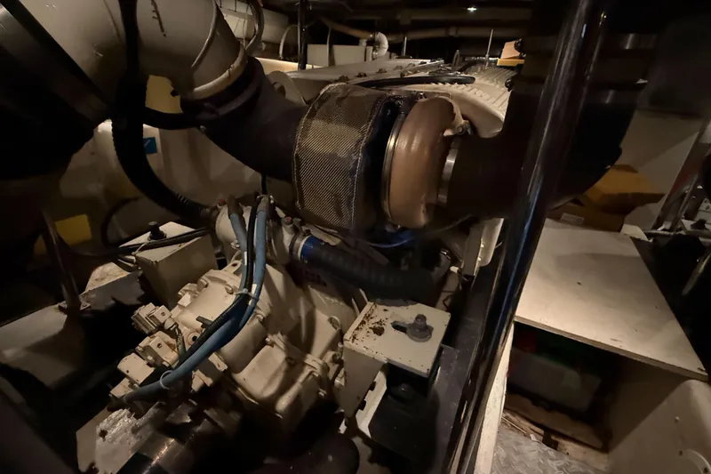 Slide: The Image of Engine room of 2001 Carver 570 Voyager Pilothouse, showcasing mechanical components and piping. - 46