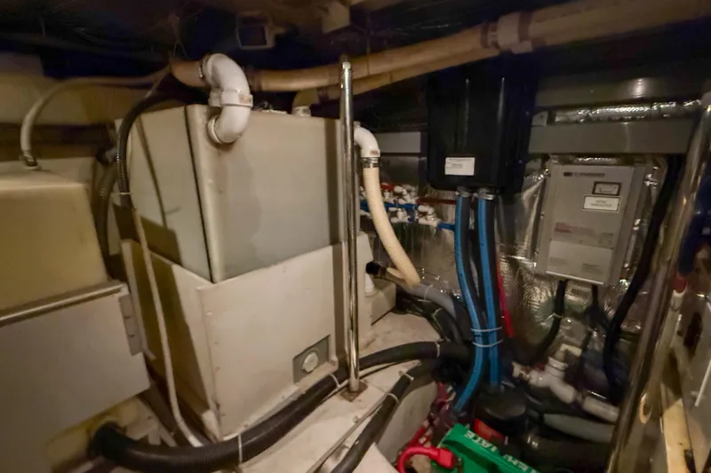 Slide: The Image of Engine room of 2001 Carver 570 Voyager Pilothouse with plumbing and equipment. - 49
