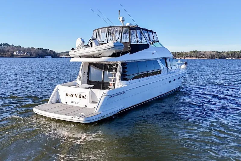 Slide: The Image of 2001 Carver 570 Voyager Pilothouse yacht cruising on a serene lake. - 5