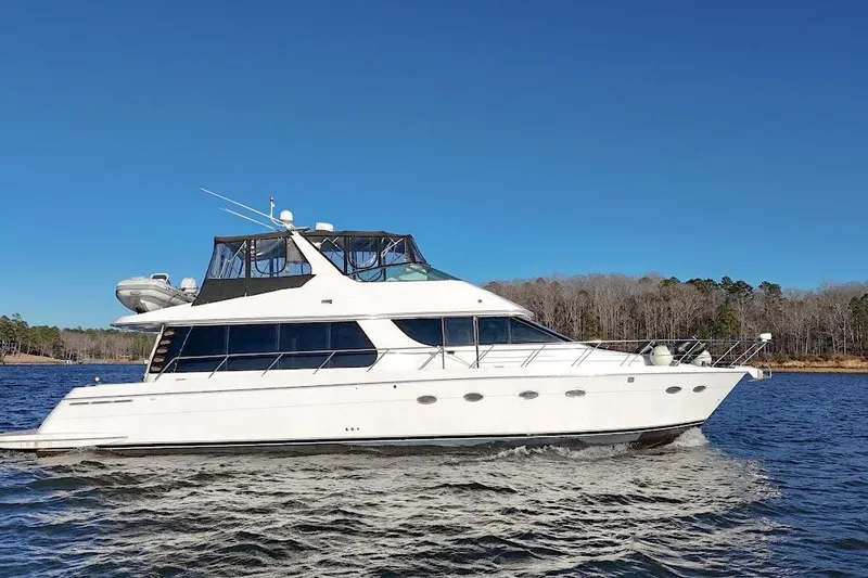 Slide: The Image of 2001 Carver 570 Voyager Pilothouse yacht cruising on a clear blue lake. - 8