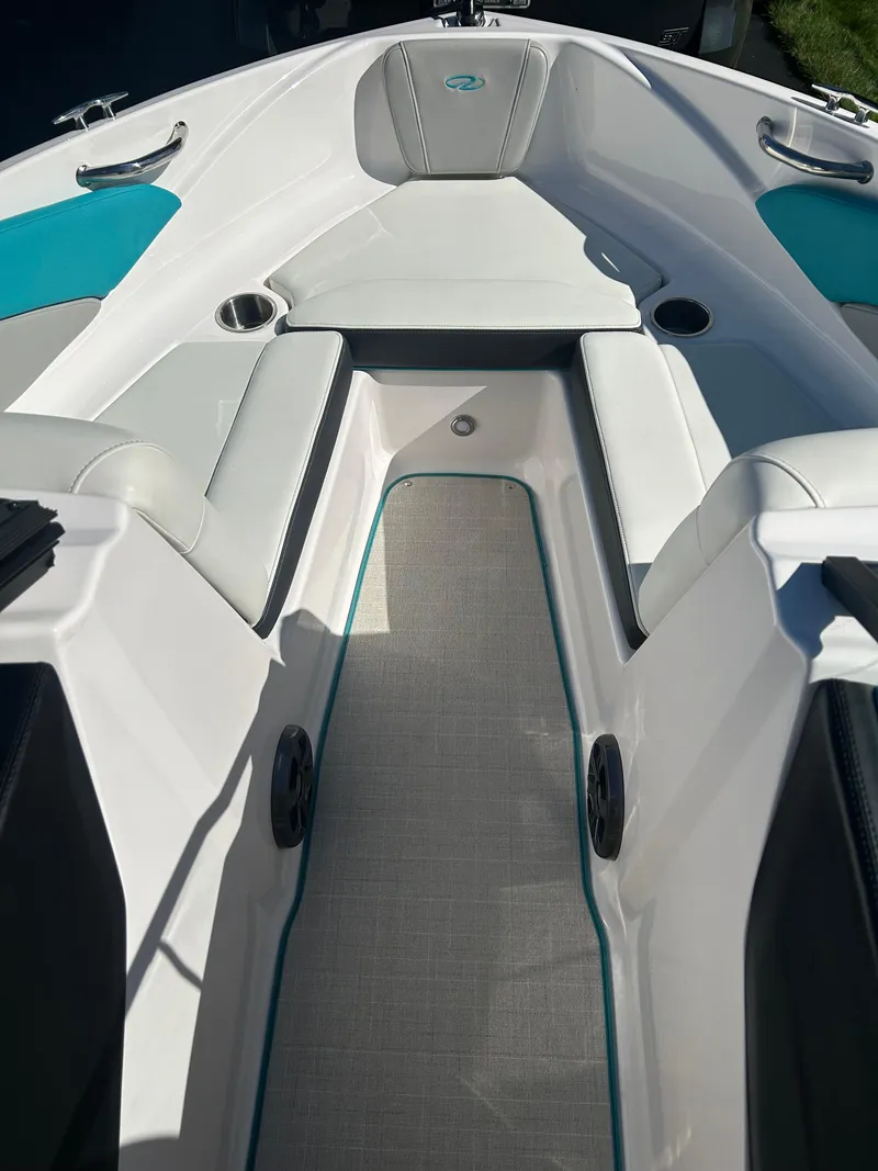 Slide: The Image of 2021 Regal 1900 ES Bowrider interior with white and teal seating, cup holders, and speakers. - 11