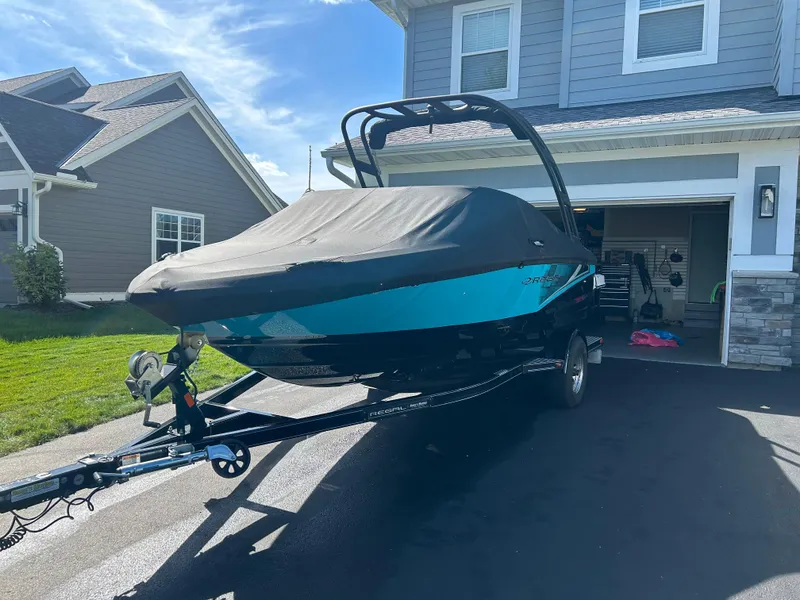 Slide: The Image of 2021 Regal 1900 ES Bowrider boat on trailer, parked in driveway near house. - 3