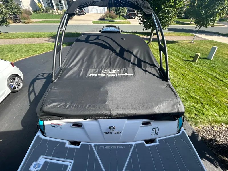 Slide: The Image of 2021 Regal 1900 ES Bowrider with cover, parked on driveway. - 7