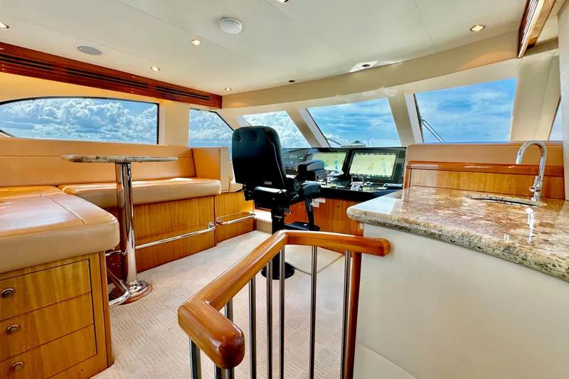 Slide: The Image of Luxurious interior of 2008 Hatteras 64 Convertible yacht with helm, seating, and panoramic windows. - 15