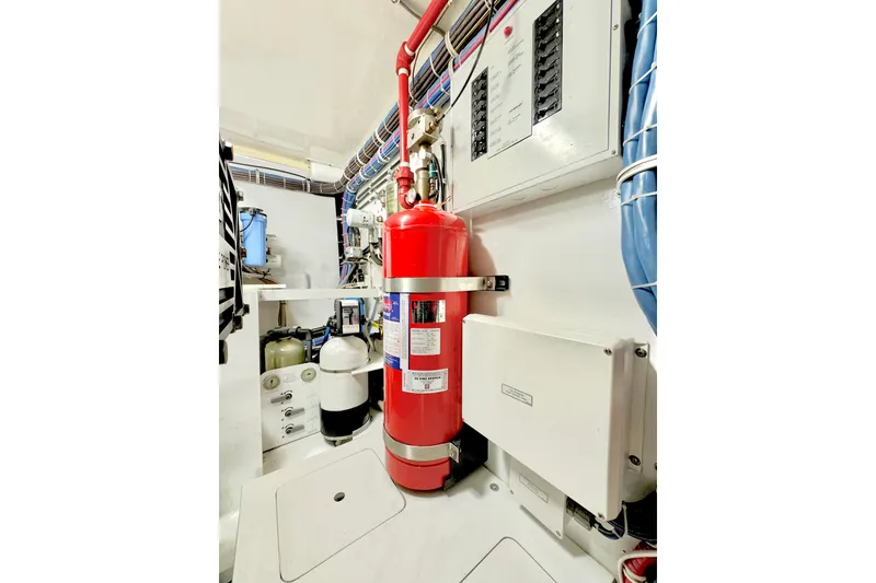 Slide: The Image of Engine room of 2008 Hatteras 64 Convertible with fire extinguisher and control panels. - 25