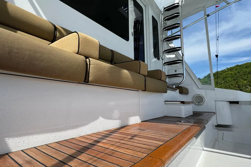 Slide: The Image of 2008 Hatteras 64 Convertible yacht with cushioned seating and wooden deck. - 7