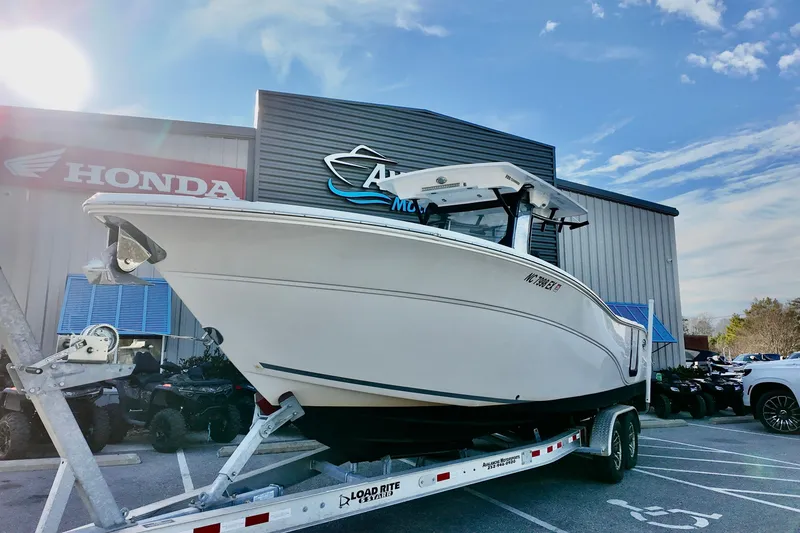 Slide: The Image of 2022 Sea Fox 288 Commander boat on trailer outside dealership under blue sky. - 2
