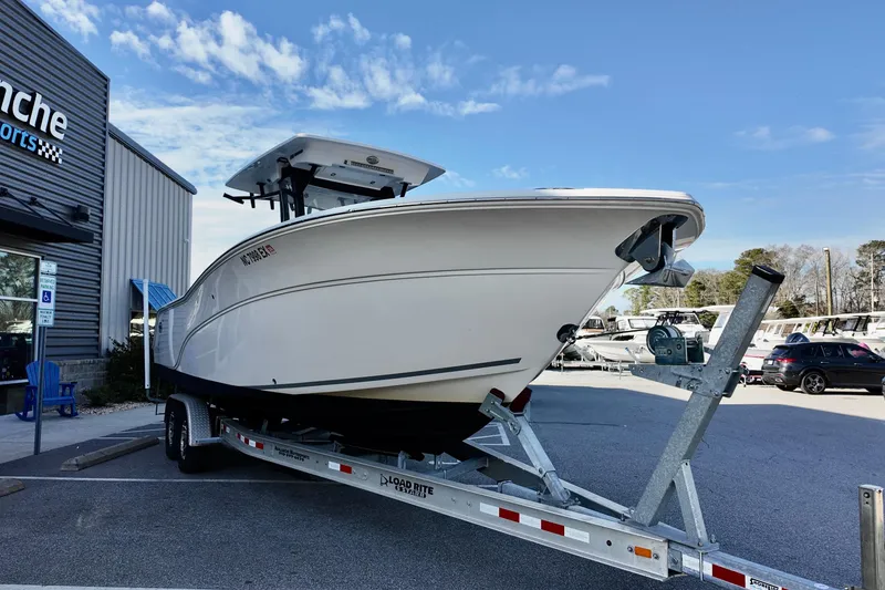 Slide: The Image of 2022 Sea Fox 288 Commander boat on trailer outside dealership under blue sky. - 3