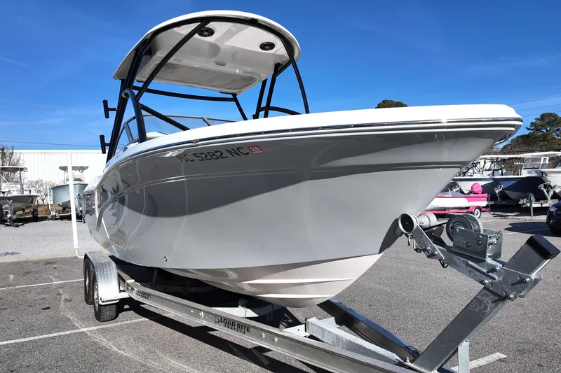 Slide: The Image of 2024 Sea Fox 228 Traveler boat on trailer, parked outdoors under clear blue sky. - 3