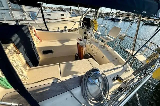 Slide: The Image of 1999 Caliber 40LRC sailboat cockpit with seating and steering wheel, docked at marina. - 22