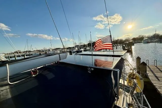 Slide: The Image of Sailboat docked at marina with American flag, Caliber 40LRC, 1999 model, sunny day. - 23
