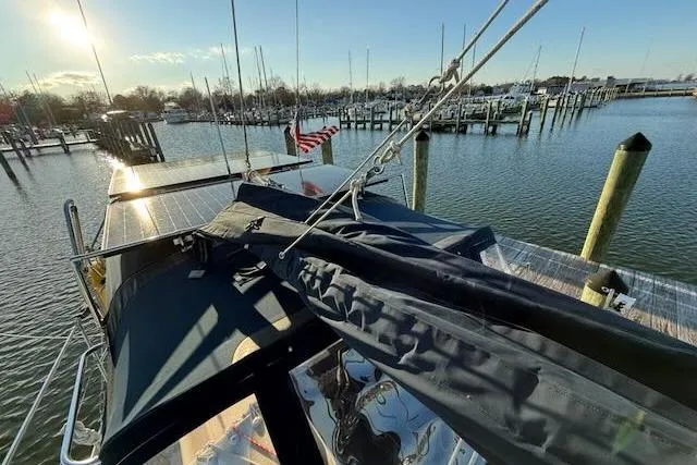 Slide: The Image of Sailboat docked at marina, Caliber 40LRC 1999, with American flag and sunny sky. - 25