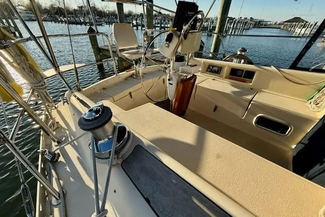 Slide: The Image of 1999 Caliber 40LRC sailboat cockpit with steering wheel, winch, and marina view. - 27