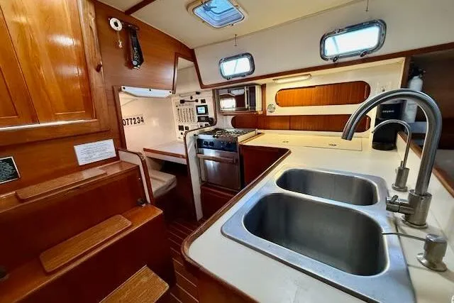 Slide: The Image of 1999 Caliber 40LRC yacht interior with kitchen, dual sinks, and wooden cabinetry. - 29