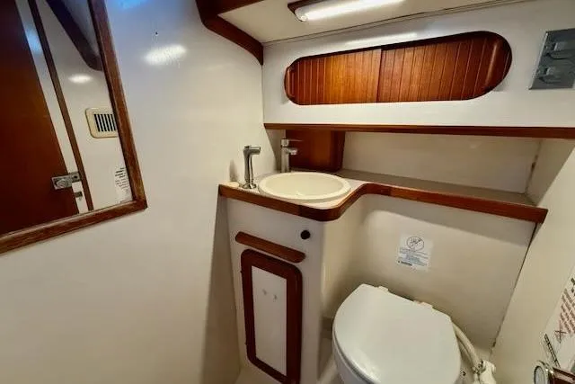 Slide: The Image of 1999 Caliber 40LRC yacht bathroom with sink, toilet, and wooden accents. - 35