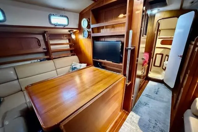Slide: The Image of Interior of 1999 Caliber 40LRC yacht with wood finishes, dining area, and TV. - 39