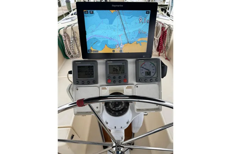 Slide: The Image of Sailboat cockpit with navigation instruments, Raymarine display, and steering wheel on 1999 Caliber 40LRC. - 4