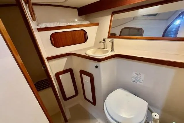 Slide: The Image of 1999 Caliber 40LRC yacht bathroom with sink, toilet, and wooden accents. - 46