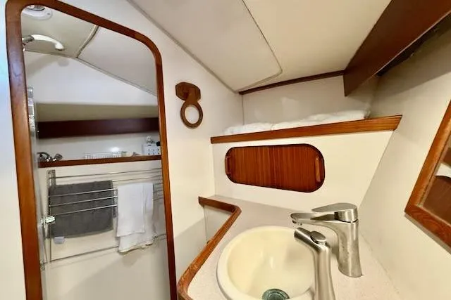 Slide: The Image of 1999 Caliber 40LRC yacht bathroom with sink, mirror, and wooden accents. - 48