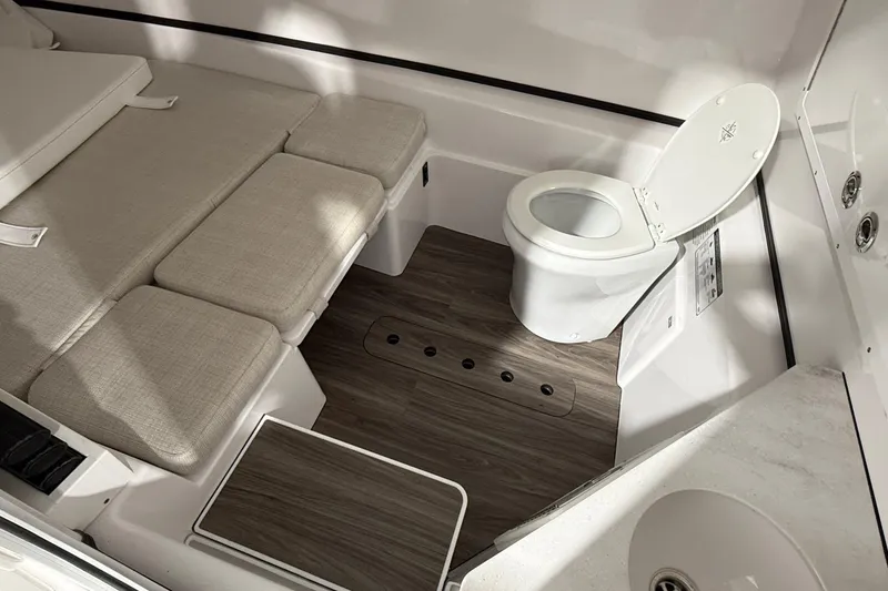 Slide: The Image of 2023 Sportsman Open 352 Center Console interior with toilet and cushioned seating. - 10