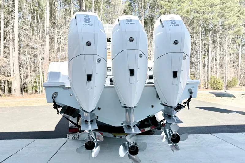 Slide: The Image of 2023 Sportsman Open 352 Center Console with triple outboard engines in a wooded setting. - 28