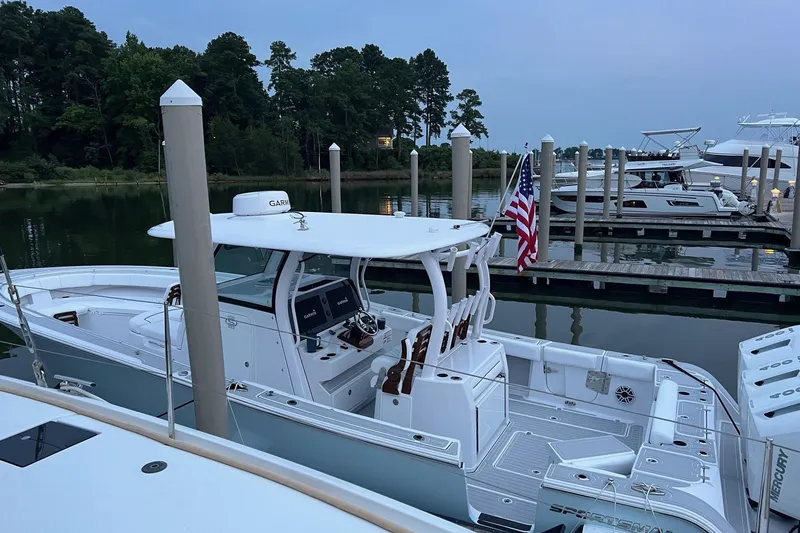 Slide: The Image of 2023 Sportsman Open 352 Center Console boat docked at marina with American flag. - 30