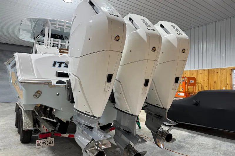 Slide: The Image of 2023 Sportsman Open 352 Center Console with triple outboard engines in a garage. - 8