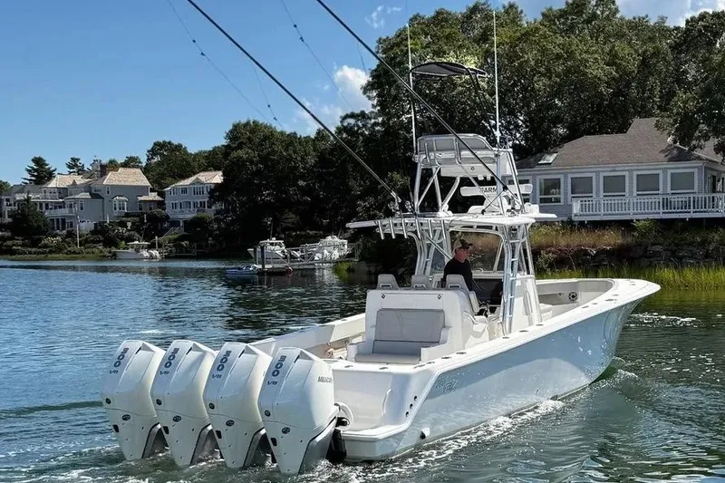 Slide: The Image of 2023 SeaVee 390Z boat with quad engines cruising near waterfront homes. - 4