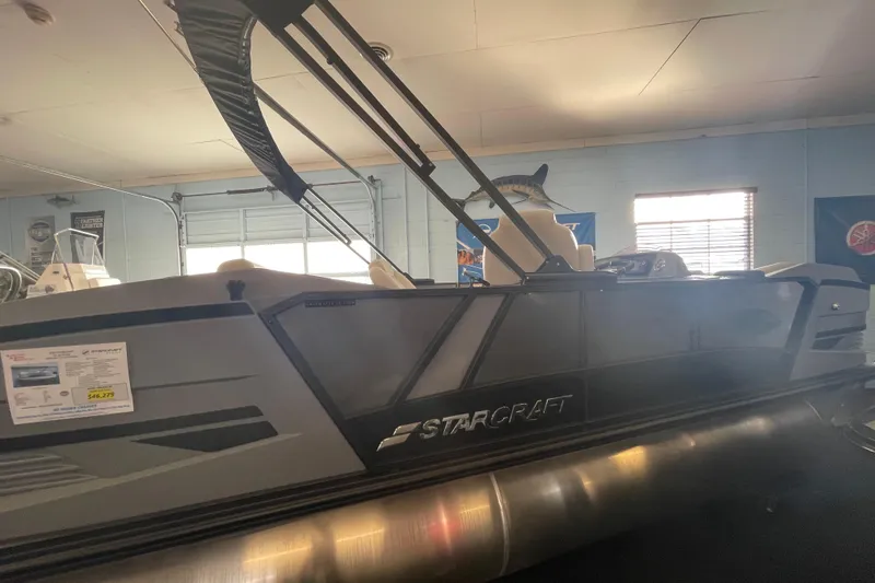 Slide: The Image of 2026 Starcraft VX 22 Q DH pontoon boat displayed indoors, showcasing sleek design. - 7