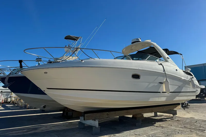 The Image of 2013 Sea Ray Sundancer 310 boat on dry dock under clear blue sky. - 0