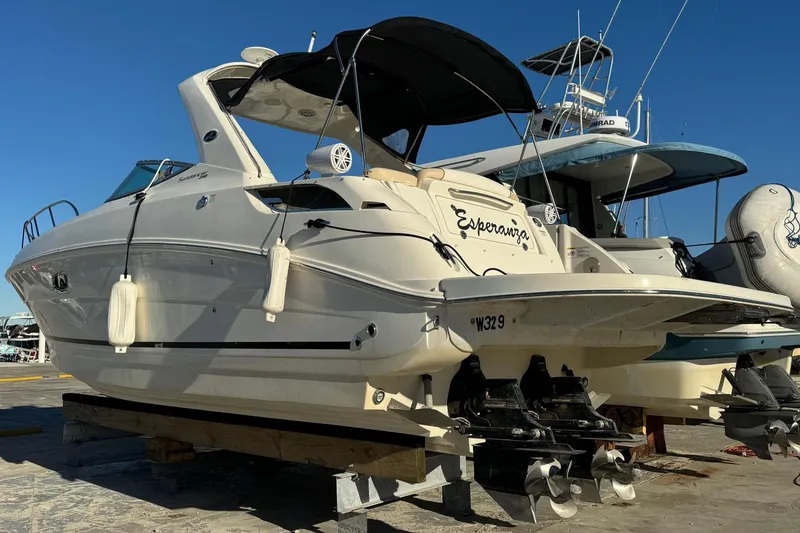 Slide: The Image of 2013 Sea Ray Sundancer 310 boat on dry dock, featuring sleek design and dual propellers. - 1