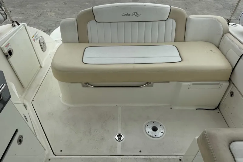Slide: The Image of 2013 Sea Ray Sundancer 310 boat interior with beige seating and storage compartments. - 14