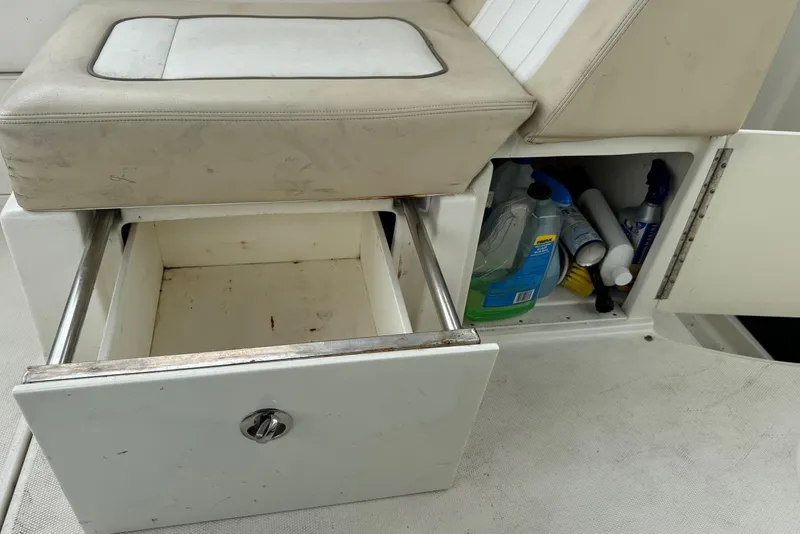 Slide: The Image of 2013 Sea Ray Sundancer 310 interior storage with open drawer and cleaning supplies. - 16